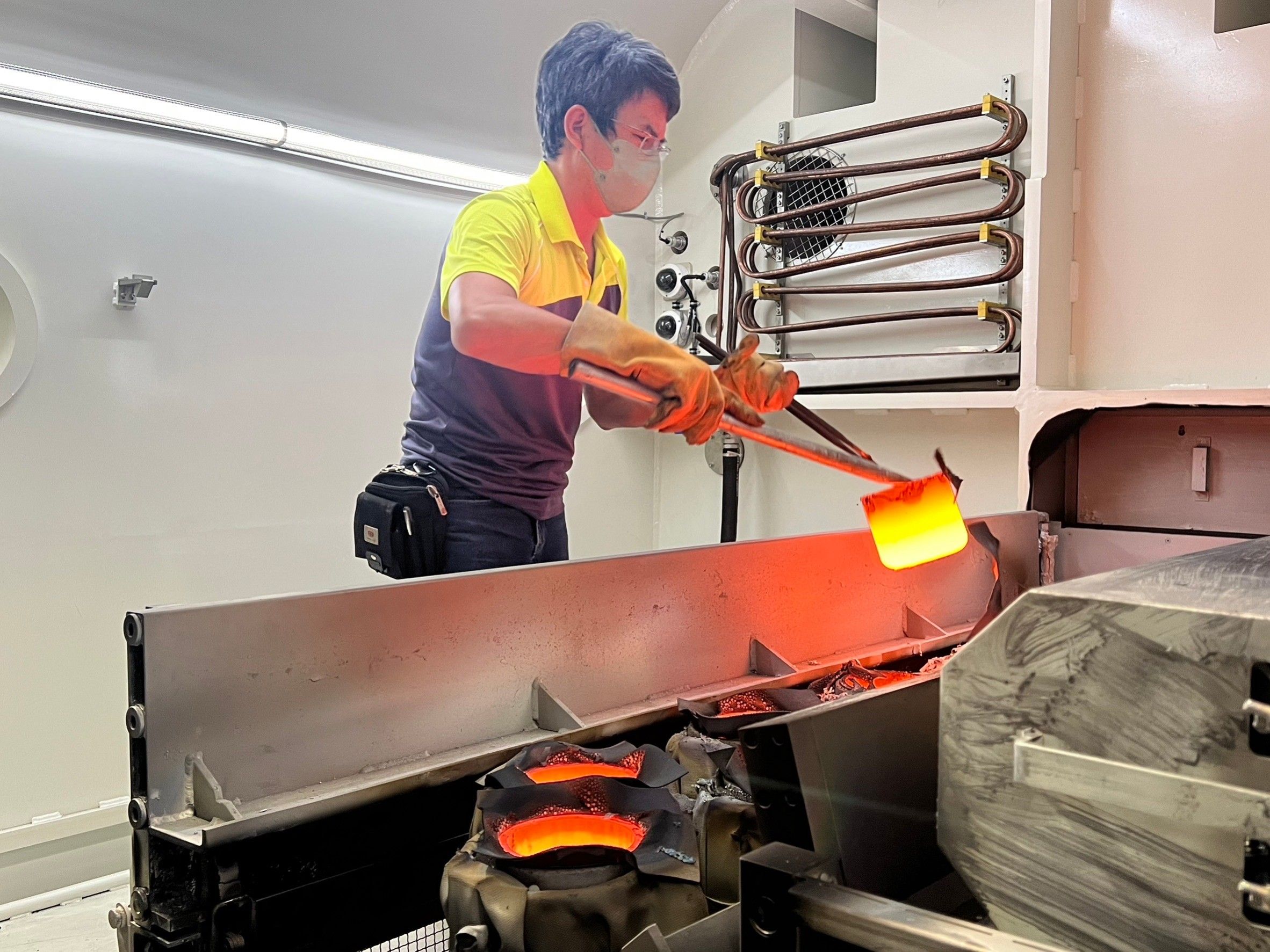 Technicians working in a crucible metallizer.