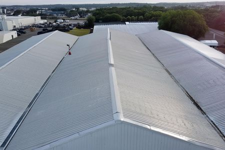 Assembly of warehouse metal roof panels using silicon sealant.