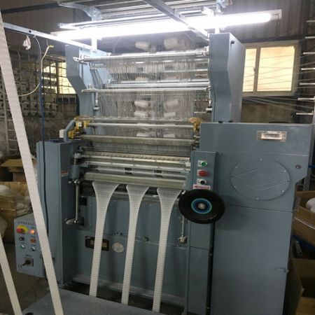 Narrow double needle bed warp knitting machine