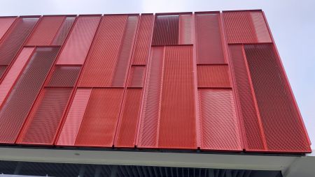 The building is surrounded by lush greenery, and bright red rectangles are intricately combined to form blocks. Designers love Shang Kai Steel's SKA20-07 expanded mesh for its ability to create a gradient effect through varying hole sizes.