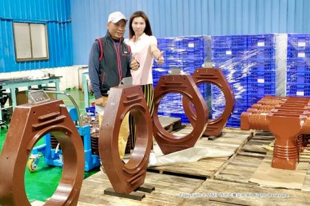 CICのチームメンバーが超大型の窓型電流トランスを披露しています。(右側には1Φ GCB用の24 kVエポキシハウジングが一部表示されています。)