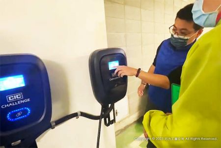 Miembro del equipo de la División Electrónica de CIC explicando cómo usar el cargador de EV