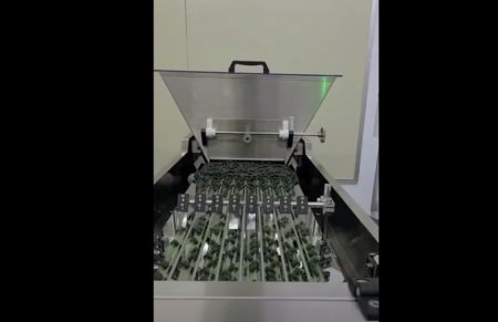 Enchimento automático de frascos. A linha de produção demonstra o despejo automático de comprimidos de algas em frascos através da medição de peso. Pessoal qualificado continua de forma contínua o processo de vedação das garrafas e completa a rotulagem externa das mesmas.
