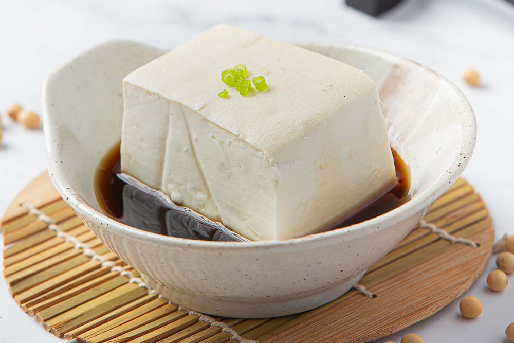 一塊灑上醬油與蔥花的美味板豆腐,象徵健康的植物性蛋白飲食趨勢