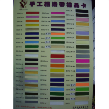 豪用牌 PP 編織帶 - 一張手工編織帶樣品卡,上面有數十個不同顏色和編號的長方形色塊,包括紅、黃、藍、綠、黑、白等多種色彩,整齊排列。