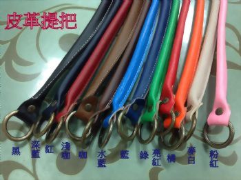 皮革手把 - 一排多種顏色的皮革提把，包括黑、紅、藍、綠、橘、粉紅等，每個提把末端都帶有金屬環，並依序排列。