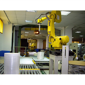 Robotic Palletizing with Automatic Pallet Supply System - The image shows an industrial production line with a large yellow robotic arm in the foreground, processing white rolled materials on a conveyor belt, and another robotic arm in the background.