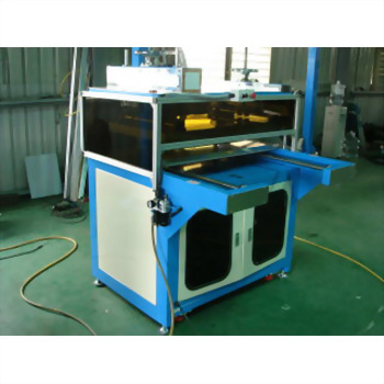 瑜珈墊捲曲機 26 - 一台藍色與米白色相間的工業機器,具有透明上蓋與下方雙門櫃體,右側延伸出一個工作平台,置於綠色地板上。